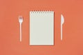 Top view of blank spiral notebook, fork and knife Royalty Free Stock Photo
