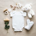 Top view of blank white baby bodysuit placed on soft beige plaid with yellow toy flowers and soft plush bears