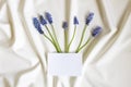 Top view of blank white greeting card Mum flowers on white folded fabric. Mothers day, wedding concept. Royalty Free Stock Photo