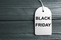 Top view of blank white tag on dark wooden background, space for text. Black Friday concept Royalty Free Stock Photo