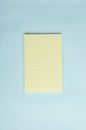 Top view of blank yellow notepad on the bright blue surface.Empty space Royalty Free Stock Photo