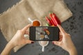Top view of a blogger taking a photo of spices in stylish ceramic dishes for her culinary blog with a smartphone