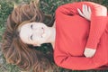 Top view of blonde smiling curvy woman with camomile daisy wheel flower in her mouth lying on the grass Royalty Free Stock Photo