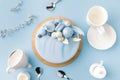 top view of blue cake with cups, plate and spoons