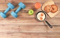 Top view of blue dumbbells , apple ,orange juice, fried eggs and pastry with copy space on wooden background Royalty Free Stock Photo