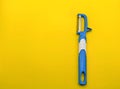 top view of blue fruit and vegetable peeler on yellow background. rule of thirds composition Royalty Free Stock Photo