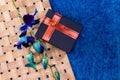 Top view of a blue gift box with red ribbons, blue orchid flower stick and a textured background. Anniversary gifts concept Royalty Free Stock Photo