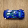 Top view of a blue Mattel Hot Wheels toy car on a wooden surface