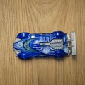 Top view of a blue Mattel Hot Wheels toy car on a wooden surface