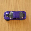 Top view of a blue Mattel Hot Wheels toy car on a wooden surface