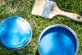 Top view of blue paint can, can lid, new brush on green grass Royalty Free Stock Photo