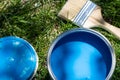 Top view of blue paint can, can lid, new brush on green grass Royalty Free Stock Photo