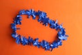 Top view of a blue plastic party necklace on an orange background Royalty Free Stock Photo