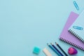 Top view of blue and purple notebooks, pencil sharpener, clips, eraser, ruler and color pencils. Royalty Free Stock Photo