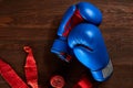 Top view of blue and red boxing gloves and bandage on wooden plank background. Royalty Free Stock Photo