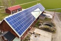 Top view of blue solar photo voltaic panels system on wooden building, barn or house roof. Renewable ecological green energy Royalty Free Stock Photo