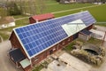 Top view of blue solar photo voltaic panels system on wooden building, barn or house roof. Renewable ecological green energy