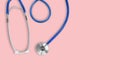 Top view of blue stethoscope medical on pink background