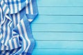 Top view of blue tablecloth on left side of wooden table