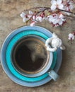 Top view of a blue vintage cup of coffee with an angel figurine and spring tree branches on wooden background Royalty Free Stock Photo