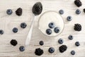 Top view of blueberries in yogurt, blackberries in a spoon and berries on the table Royalty Free Stock Photo