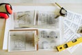 Top view of blueprints, ear defenders, level and tools on architect workspace at construction site