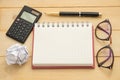 top view blur fucus. glasses, round paper, empty notebook,calculator and ballpoint pen all of this putting on wooden are Royalty Free Stock Photo