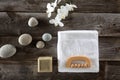 Top view, bodycare concept with soap, towel, pebbles and flowers