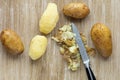Top view of boiled potatoes in jackets and scrubbed on the wooden background