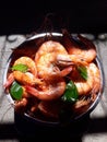 Top view, boiled shrimp and kaffir lime leaves, vegetables, herbs on a mouthwatering dish, seafood.
