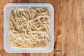 Top view of boiled spaghetti pasta in plastic box on wooden table. Cooking at home. Start and promote your food business Royalty Free Stock Photo