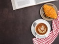 Top view of a book with croissant on a plate and a white coffee cup on a table Royalty Free Stock Photo