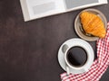 Top view of a book with croissant on a plate and a white coffee cup on a table. Royalty Free Stock Photo