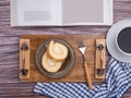 Top view of a book with roll cake on a plate on a wooden tray and a white coffee cup on a wooden table. Royalty Free Stock Photo