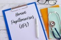 Top view of books,stethoscope,glasses,pen,clipboard and paper written with Human Papillomavirus HPV. Healthcare and medical