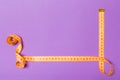 Top view of border frame made of measure tape with empty space for your idea. Sewing and keeping fit concept on purple background Royalty Free Stock Photo