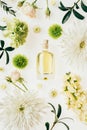 top view of bottle of aromatic perfume surrounded with flowers and green branches