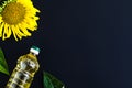 Sunflower oil bottle and flower on black background Royalty Free Stock Photo