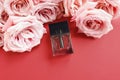 Top view of bottle of perfume with rose flowers on a red background. Eau de toilette. Eau de parfum. Mockup, flatlay Royalty Free Stock Photo