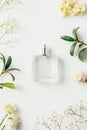 top view of bottle of perfume surrounded with flowers and green branches