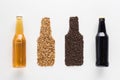 Top view of bottles of dark and light beer near wheat and coffee grains isolated on white.