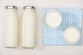 Top view of bottles and glasses of homemade yogurt on plaid cloth