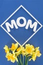 top view of bouquet of daffodils and word mom in frame