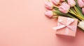 Top view of a bouquet of tulips and a gift box with a ribbon bow