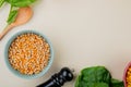 top view of bowl of corn seeds with spinach and wooden spoon on white background with copy space