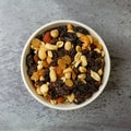 Top view of a bowl filled with high energy trail mix on a gray mottled background in natural light Royalty Free Stock Photo