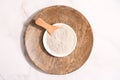 Top view on bowl with gray cosmetic clay on white marble table - mineral powder