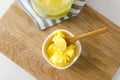 Top view of bowl and jar with ghee or clarified butter on chopped board. Healthy eating and using organic fresh made products Royalty Free Stock Photo