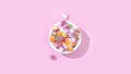 Top view of a bowl of jelly candies with different flavours isolated on a pastel pink background