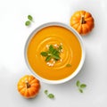 Top view of a bowl with pumpkin soup and basil leaves. Pumpkin as a dish of thanksgiving for the harvest, picture on a white Royalty Free Stock Photo